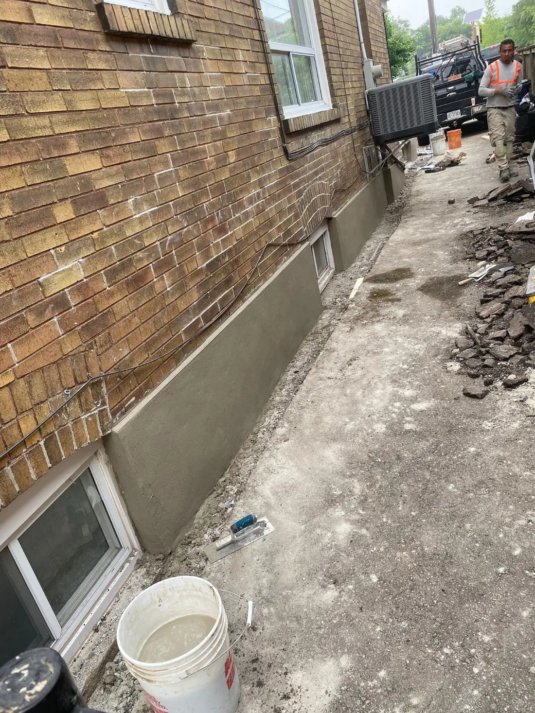 Fresh parging finish beneath an exterior brick wall