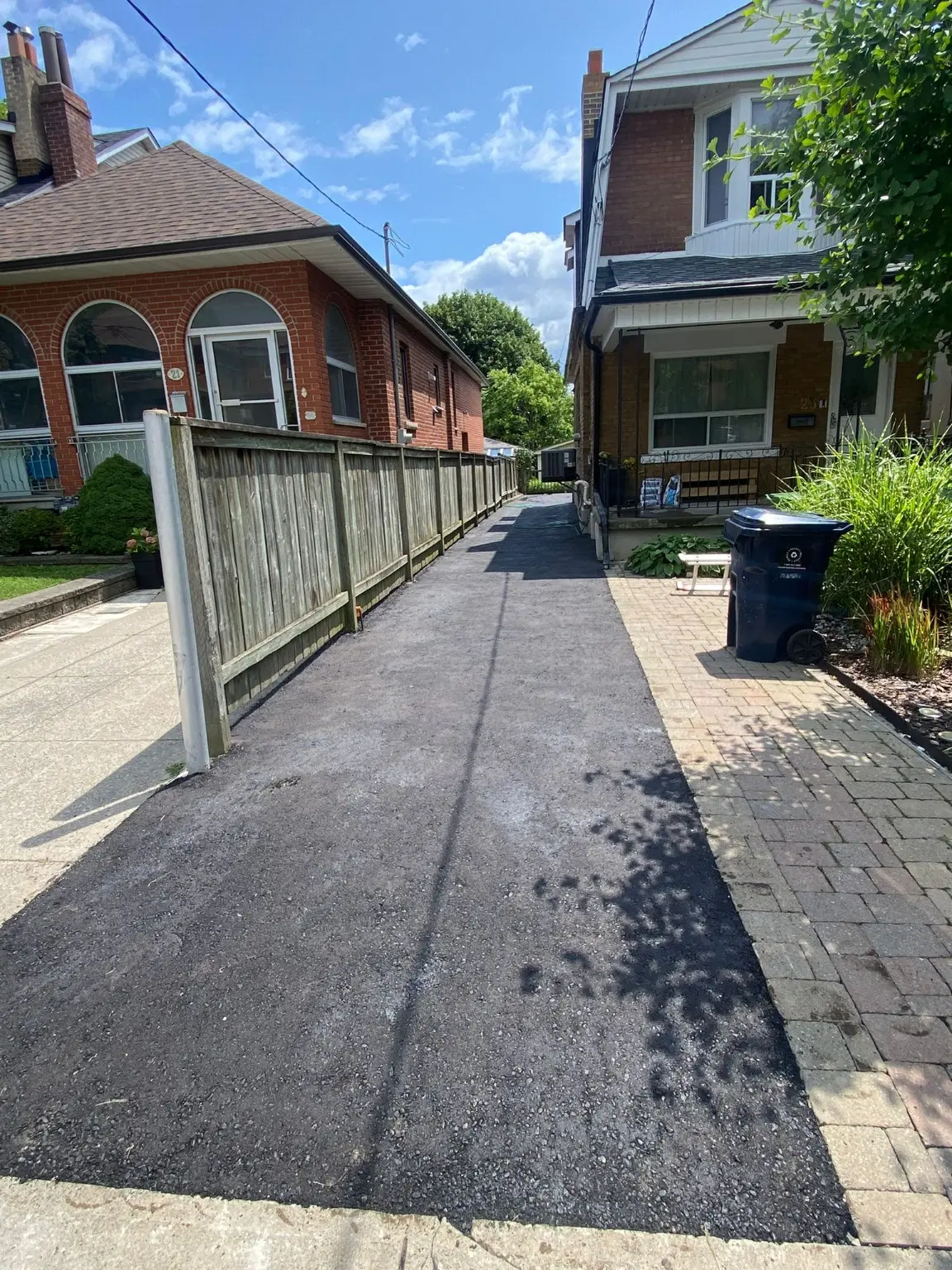 Fresh asphalt driveway completed beside a Toronto home