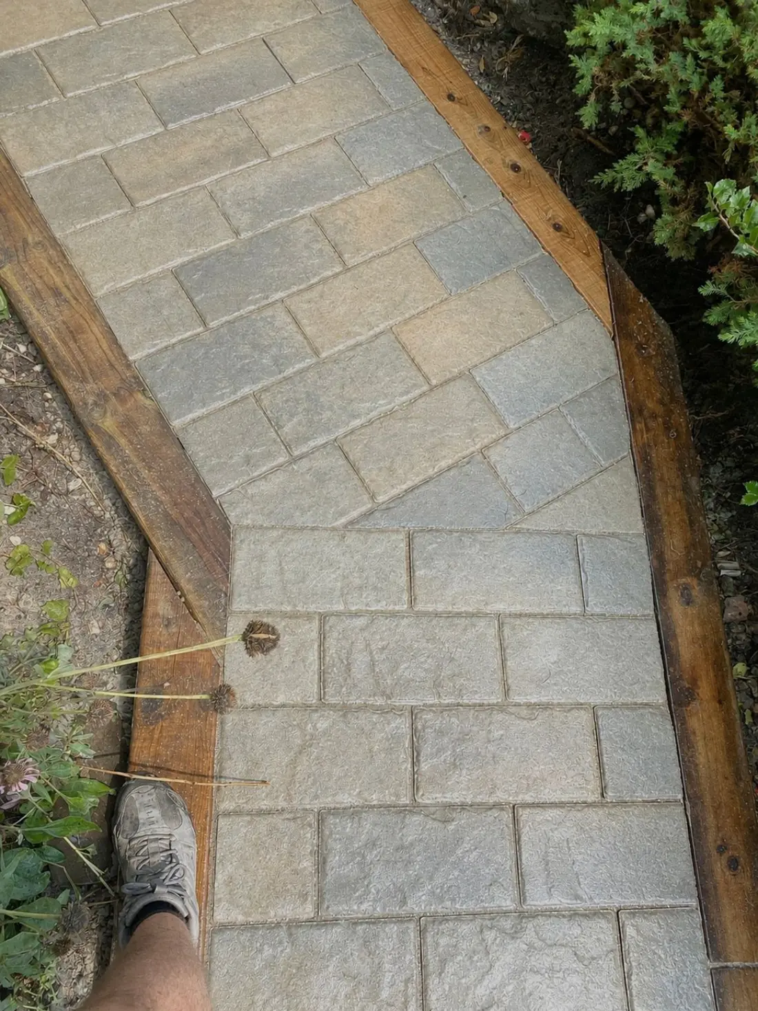 Close view of light interlock pavers within a timber border